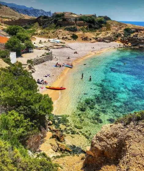 Petite plage de sable au fond d’une calanque à l’eau turquoise
