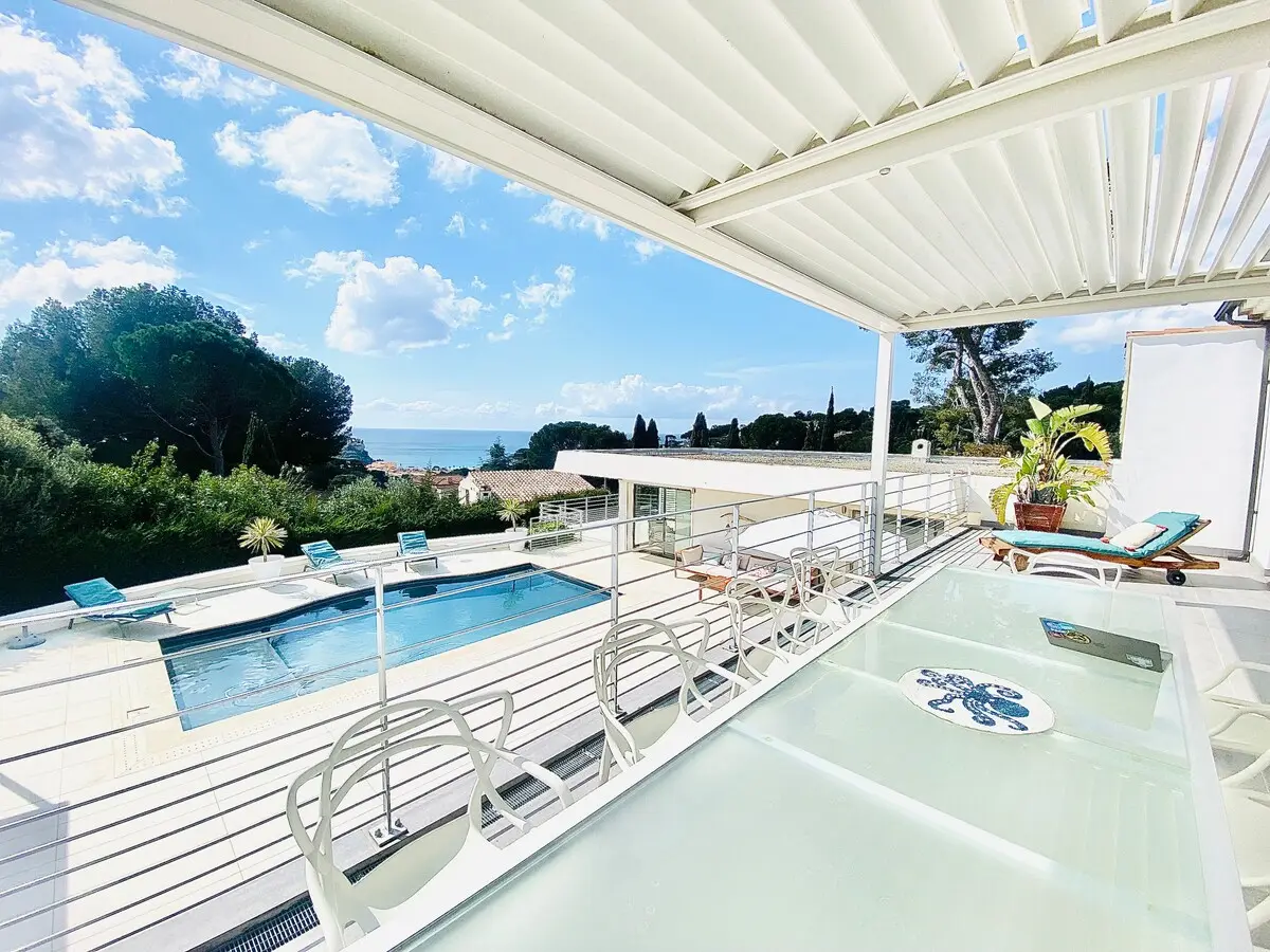 Pergola bioclimatique ouverte sur le bassin et la vue