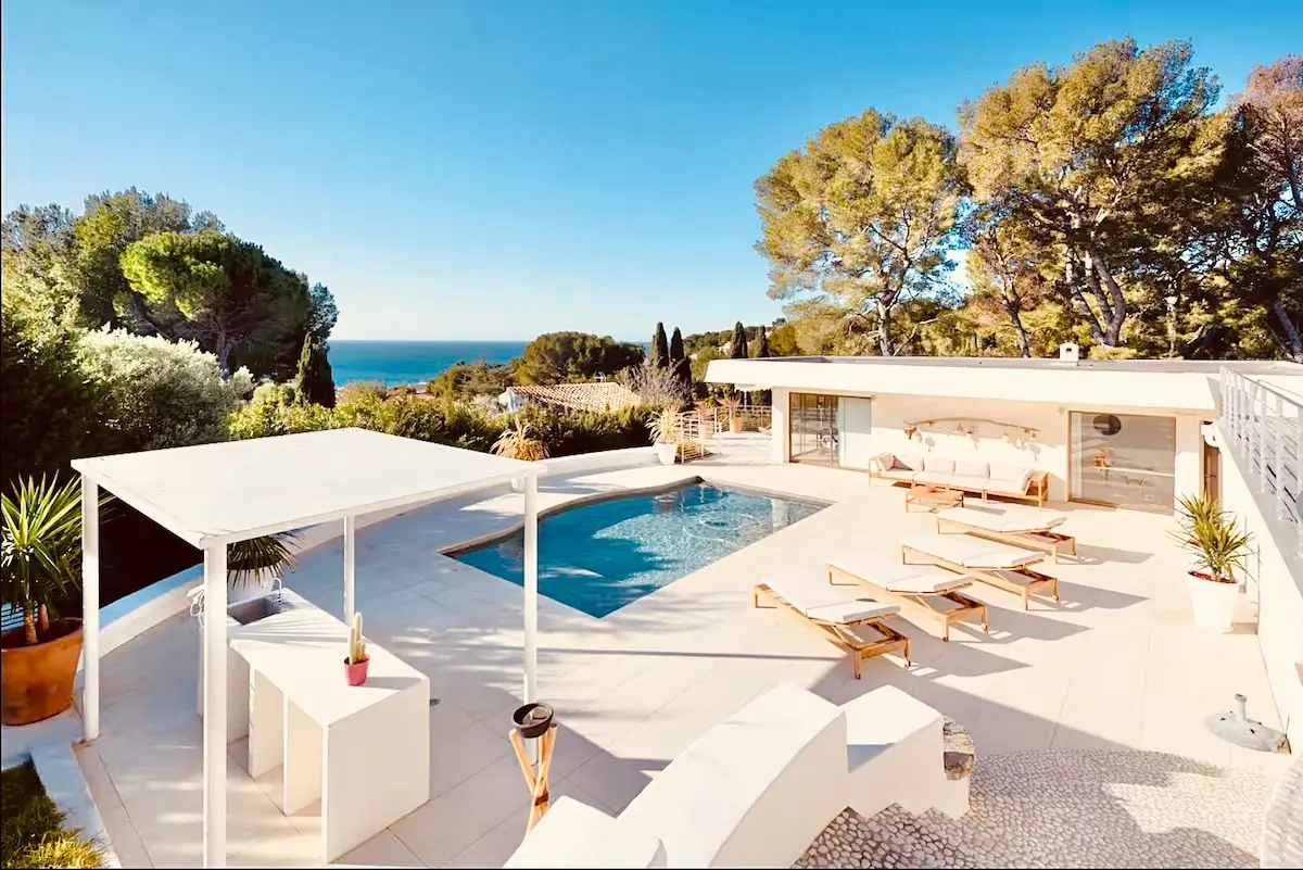 Le bassin de la villa et sa pergola, la Méditerranée au loin entre les pins