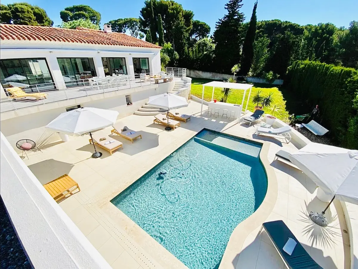 Vue plongeante sur la piscine, ses parasols et ses transats