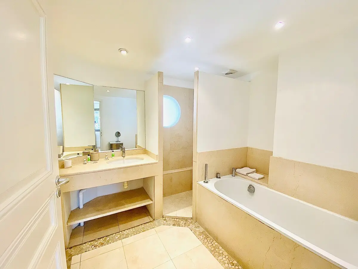 Salle de bain avec baignoire et hublot